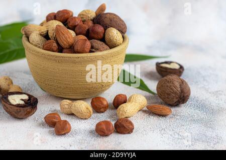 Almonds, walnuts, hazelnuts and peanuts, mix of nuts. Contains beneficial vitamins and minerals. On a gray background. Copy space. Stock Photo