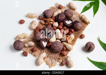 Almonds, walnuts, hazelnuts and peanuts, mix of nuts. Contains beneficial vitamins and minerals. On a gray background. Copy space. Stock Photo