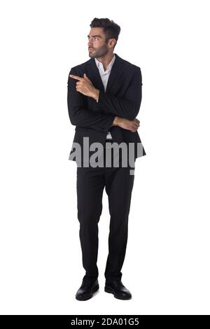 Full length portrait of young handsome business man in black suit pointing showing copy space studio isolated on white background Stock Photo
