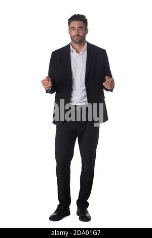 Full length portrait of young handsome business man in black suit holding something in hands studio isolated on white background Stock Photo