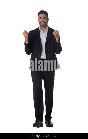 Full length portrait of successful excited happy business man in black suit looking at camera hold fist ok yes gesture studio isolated on white backgr Stock Photo