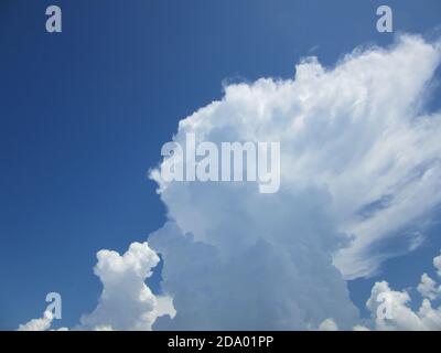 Fluffy white clouds contrasted against a brilliant blue sky Stock Photo