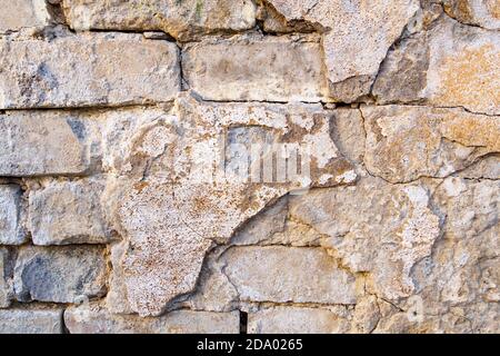 Peeling paint, stucco on an old brick wall. Cracked aiged background. Stock Photo