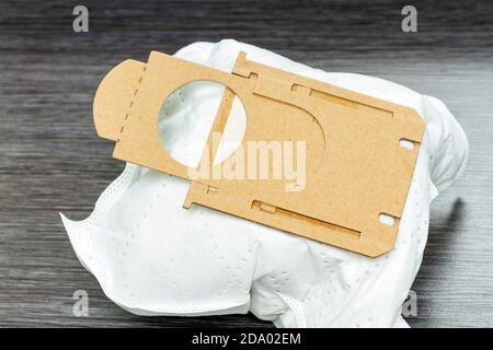 close-up of full synthetic vacuum cleaner bag on brown wooden background Stock Photo