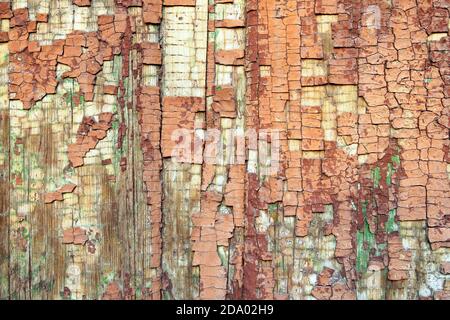 Red cracked paint on a wooden background. Cracked brown wooden surface. Weathered texture backdrop Stock Photo