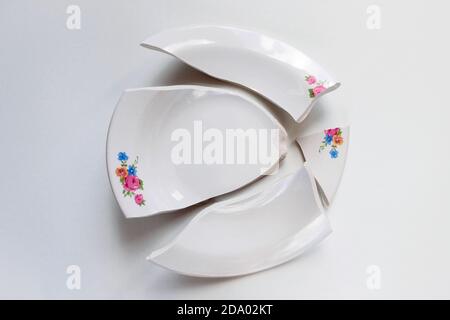 broken white plate with flowers pattern on white background Stock Photo