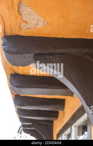 Close up of old wooden black beams with yellow cracked broken and missing plaster Stock Photo