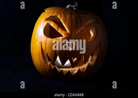 Jack O'Lantern lighted pumpkin with evil smile isolated on a black background- Halloween tradition Stock Photo