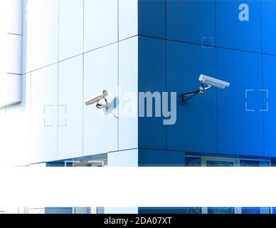 Two surveillance cameras on the building are deployed in opposite directions. Stock Photo
