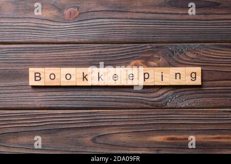 bookkeeping word written on wood block. bookkeeping text on table, concept. Stock Photo
