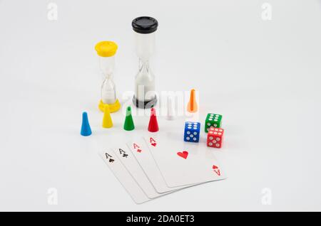 Colored dice with an hourglass and playing cards on white background Stock Photo