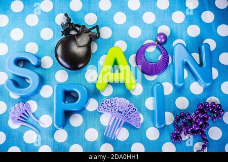 Top view shot of the word "Spain" made of plastic letters and castanet on blue dotted background Stock Photo