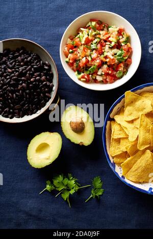 Ingredients for cooking chilaquiles - black beans, tortilla chips, corn and salsa Stock Photo
