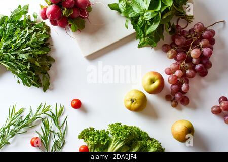 Flatlay with various vegetarian cooking ingredients: grapes, lettuce, apples and herbs Stock Photo