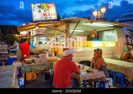 Outdoor dining in a plaza among roulotte food vans at Papeete on the island of Tahiti, Tahiti Nui, Society Islands, French Polynesia, South Pacific. Stock Photo