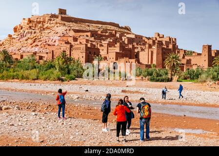 Tourists in front of Ksar Ait Ben haddou, old Berber adobe-brick village or kasbah. Ouarzazate, Drâa-Tafilalet, Morocco, North Africa Stock Photo
