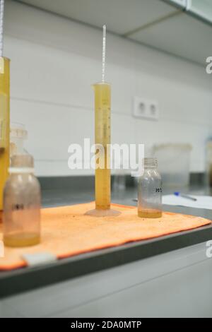 Yellow chemical liquid in glass tube placed on table in contemporary laboratory for conducting scientific research Stock Photo