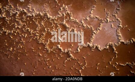Textured background of weather metal wall with curved lines of corrosion on sunny day in city Stock Photo