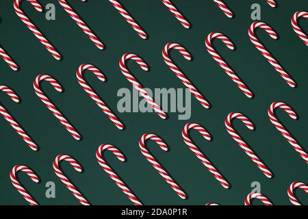 Top view composition with red Christmas candy canes arranged in rows on black background Stock Photo