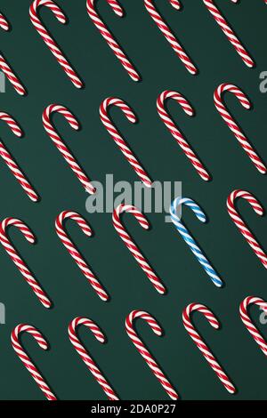 Top view composition with blue and red Christmas candy canes arranged in rows on black background Stock Photo
