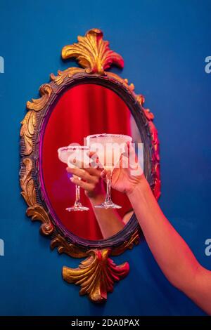Crop anonymous female with margarita Mexican cocktail consisting of tequila orange liqueur and lime juice served with salt on rim of glass Stock Photo