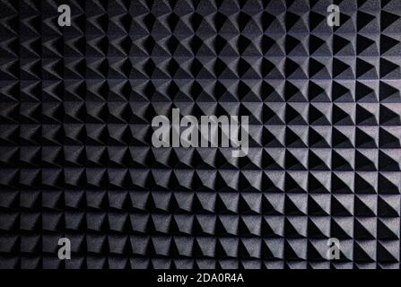 Textured background of wall with black geometric soundproof foam with pyramid shaped pattern in recording studio Stock Photo
