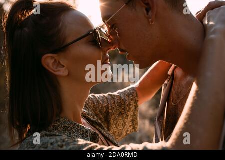 Little sailing boat in the sea at sunset with the sun and clouds in the background. Sailing on a summer adventure in the Mediterranean sea Stock Photo