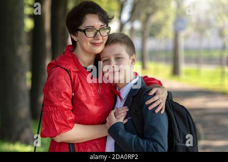 Happy mother and son embracing each other. Mom and teen son in the Park after school. A mother's love, raising children, trusting family relationships Stock Photo