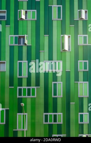 Contemporary building with vivid green facade and opened windows