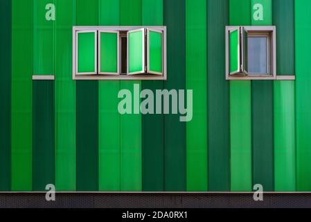 Contemporary building with vivid green facade and opened windows