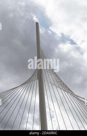 From below of white contemporary suspension bridge with high column connecting many cables together against blue sky Stock Photo