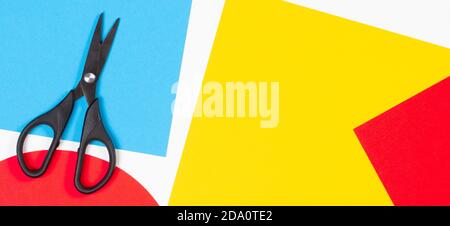 Colorful paper sheets and scissors on white desk background. Top view, copy space Stock Photo