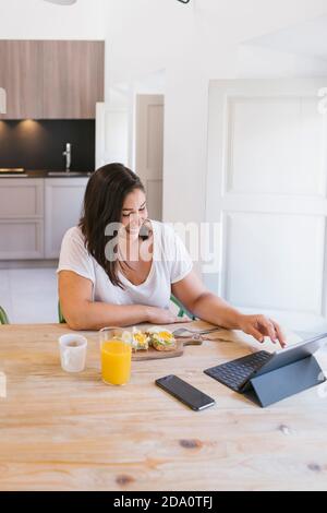 Working brunette Woman having breakfast at home Stock Photo