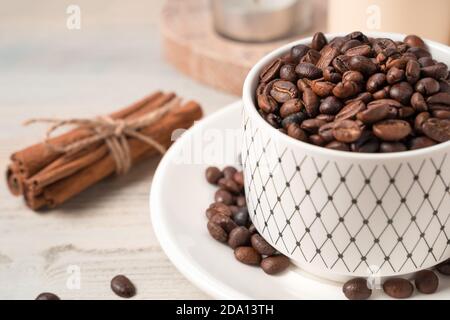 Coffee beans in a mug, blurred in the foreground on a light background. Stock Photo