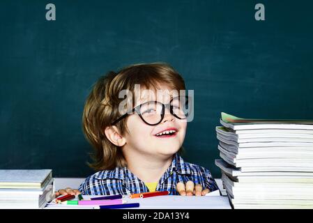 Happy mood smiling broadly in school. School kids against green chalkboard. Hard exam. Little student boy happy with an excellent mark. Stock Photo