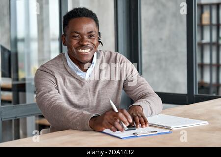 Cheerful african business man wearing headset laughing looking at camera. Stock Photo