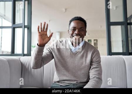 Happy african young man waving hand looking at camera video conference calling.