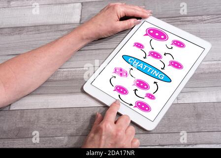 Chatting concept shown on a tablet used by a woman Stock Photo