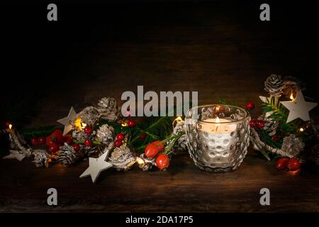 Candle in a glass and natural Christmas decoration on a dark rustic wooden background, copy space Stock Photo