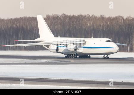 Huge white wide-body cargo airplane taxing on runway for take off at sunny winter day. Transportation, cargo, aviation. Stock Photo