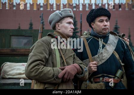 Moscow, Russia. 7th of November, 2020 People in the uniform of soviet soldiers and with weapons from the beginning of the World War II stand on the Red Square in the center of Moscow on background of the wall of the Moscow Kremlin, Russia Stock Photo