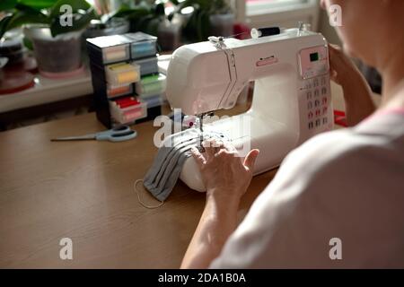 Woman hands using the sewing machine to sew the face mask Stock Photo