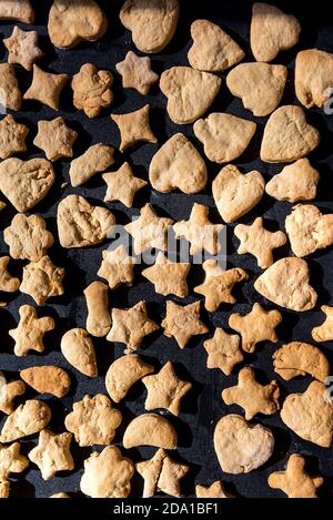 Own pastries, shortbread, cinnamon cookies in various shapes, taken straight from the oven. Christmas sweets cookies in the shape of stars, moons and Stock Photo
