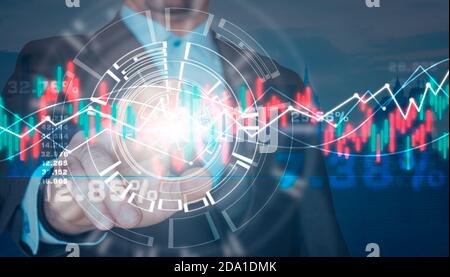 Businessman's hand touching a virtual screen with graphs and financial data.Stock market concept Stock Photo