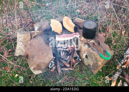 pork rib and two slice of bread grilled on portable titanium grill in Nebrodi Park, Sicily Stock Photo