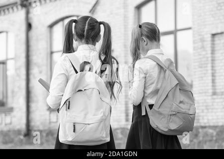 Study and spread knowledge. Little children carry heavy backpacks. Knowledge day. Back to school. Education and study. Knowledge skills. Private teaching. September 1. School time. Knowledge matters. Stock Photo