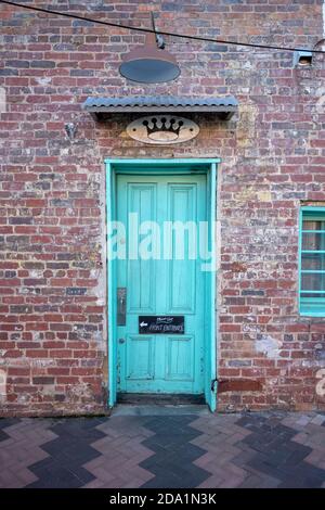Green Door On Brick Wall with brick sidewalk Stock Photo