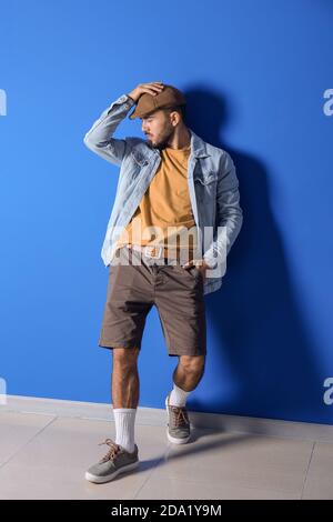 Fashionable young man on color background Stock Photo