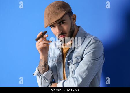 Fashionable young man on color background Stock Photo