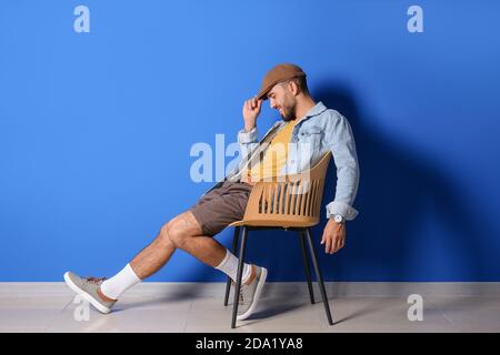 Fashionable young man on color background Stock Photo